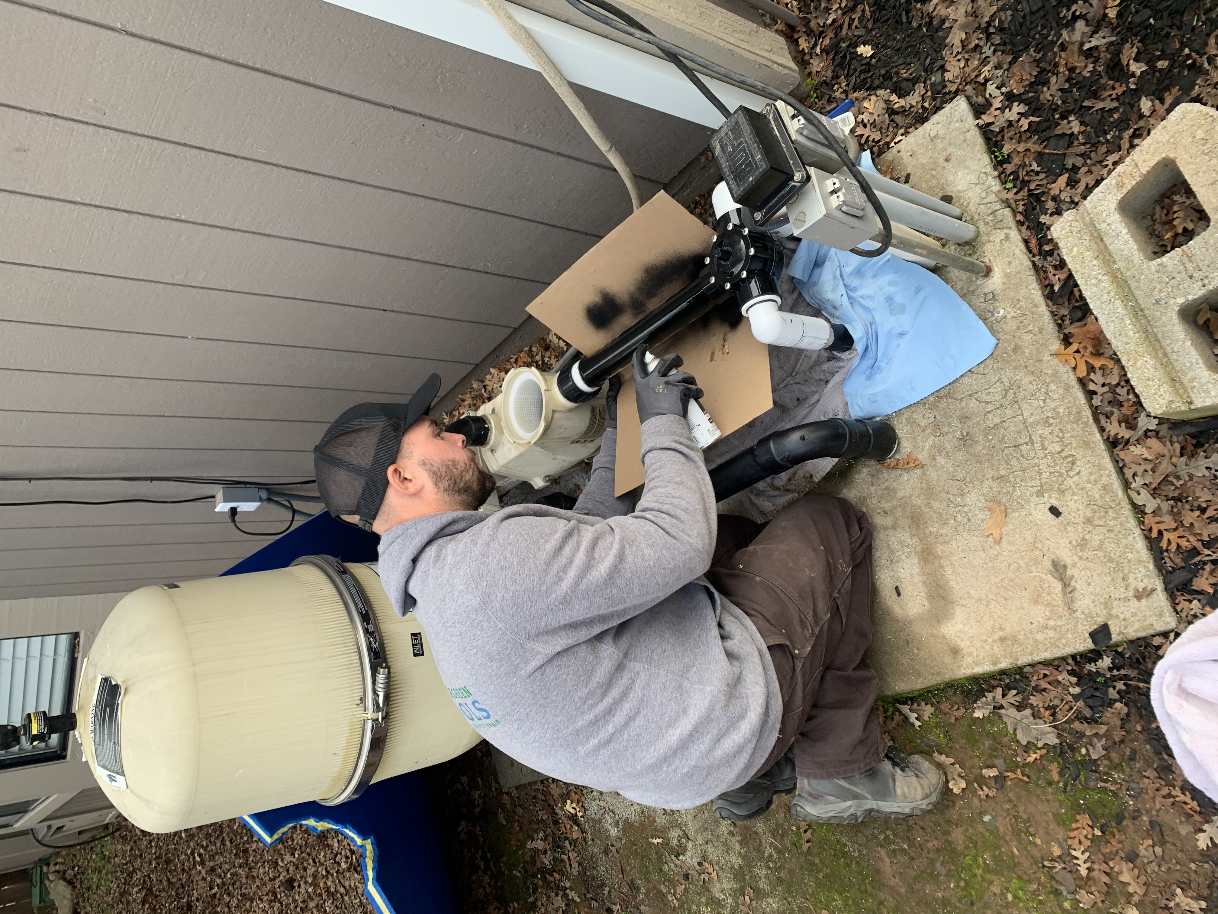 Vintage Pool Service technician brushing a clean residential pool